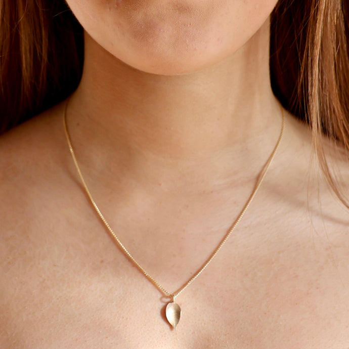 Delicate gold leaf pendant on fine gold chain.